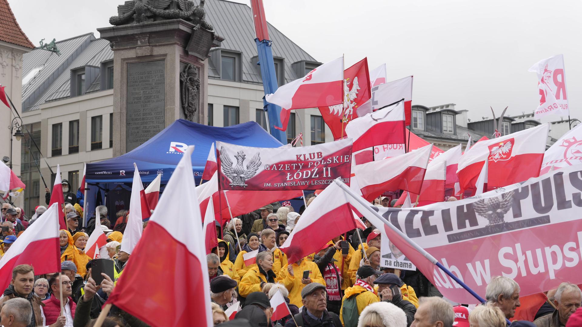 Demonstranten auf dem Schlossplatz in Warschau. Sie schwenken Fahnen.