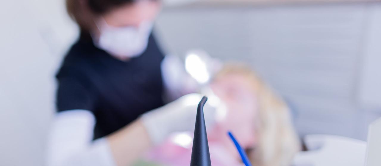 Eine Person wird in einer Zahnarztpraxis behandelt.