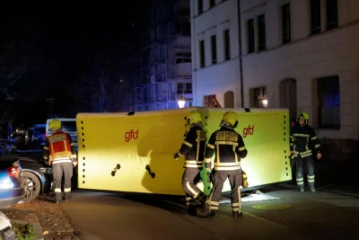 Einsatz in Chemnitz: Werkzeuge fliegen auf Straße - Einsatzkräfte der Feuerwehr Chemnitz bringen ein Sprungpolster in Stellung, um einen möglichen Sprung aus dem Fenster abzufangen.