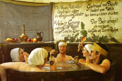 Der heißeste Platz in der Klosterstraße: Baden auf dem Weihnachtsmarkt - Zwischen Glühwein, Gauklern und Geknister: In Chemnitz wartet ein neues Badehaus mit Holzzuber voller Wärme auf winterkalte Seelen.