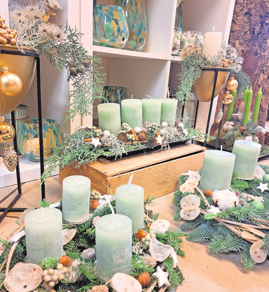 Kerzen in beispielsweise zartem Mint-Grün zieren einige der Adventskränze und -gestecke bei Blumen Wohlers. Foto: Kathrin Schöning