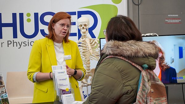 Vanessa van Engelen von der Eva-Hüser-Schule erklärt Besuchern der Jobmesse Bielefeld die Karrierechancen. - © Barlag
