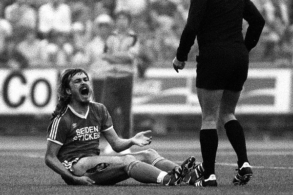 Ewald Lienen (li., Bielefeld) hält sich nach Norbert Siegmanns (Bremen) brutalem Foul den aufgeschlitzten Oberschenkel - © imago/Sven Simon