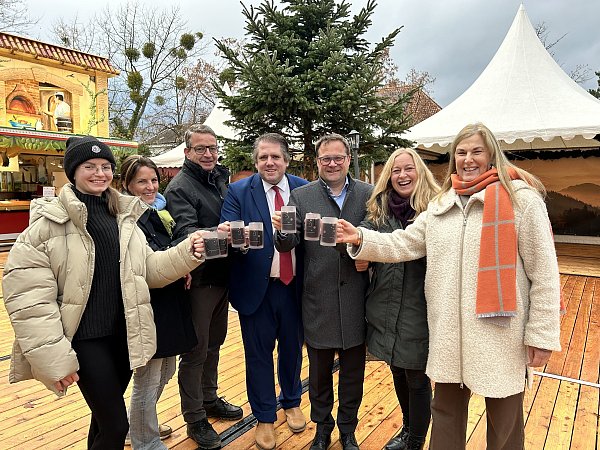 Anstoßen auf den Weihnachtsmarkt: Lisa, Ute und Daniel Lemoine (v. l.) freuen sich mit Marian Zachow, Lars Bökenkröger, Kristina Quest und Beate Krämer auf Bad Oeynhausen im Licherglanz. - © Nicole Sielermann