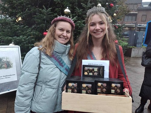Die Heideköniginnen Lisanne (l.) und Chiara verkaufen Jubiläumspralinen. - © Birgit Nolte