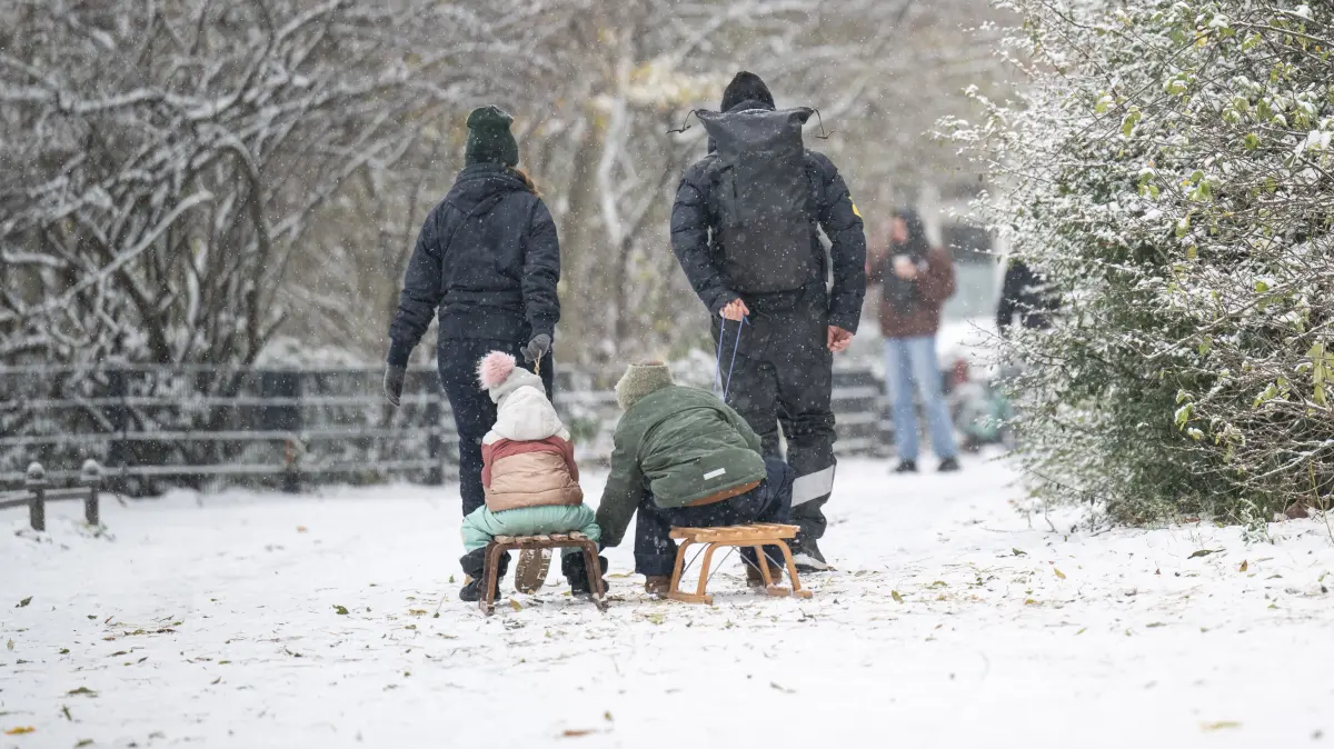 Zwei Erwachsene ziehen zwei Kinder auf Schlitten durch den Volkspark Friedrichshain. Schnee und Glätte haben Berlin und Brandenburg weiterhin im Griff. +++ dpa-Bildfunk +++