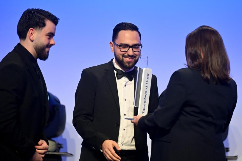Berat Davulcu (Mitte) erhält den Award für sein Engagement.