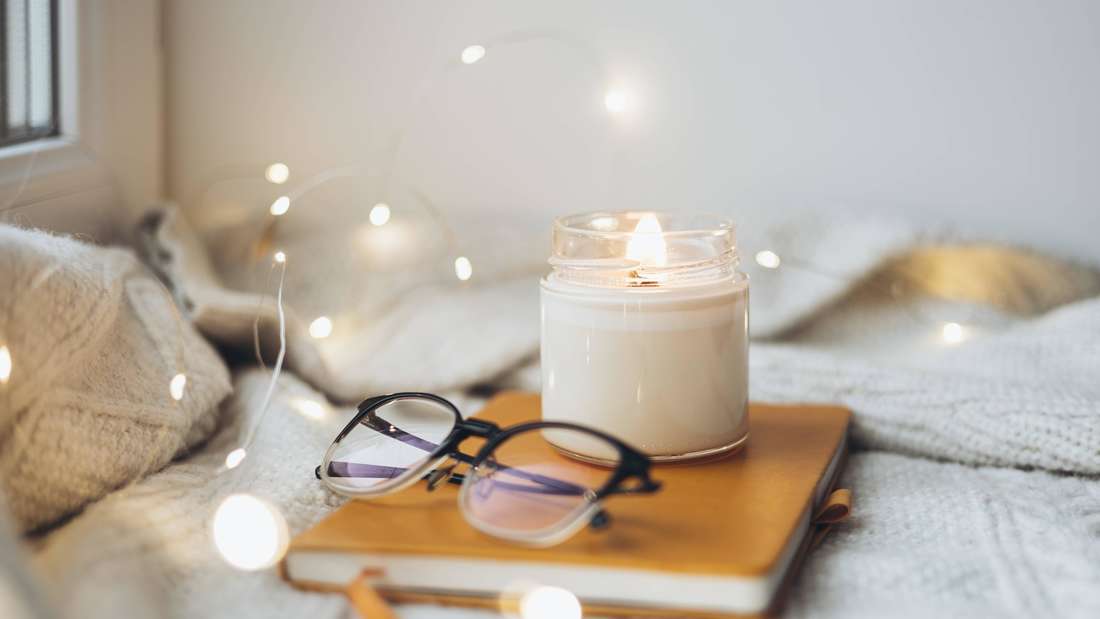 Eine Lesebrille auf einem Notizblock mit weihnachtlichem Hintergrund