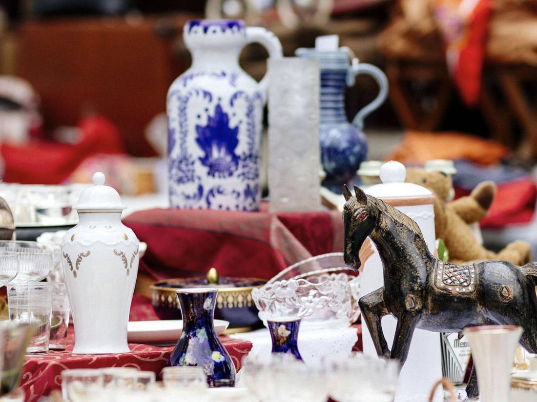 Verschiedene Gegenstände stehen auf einem Tisch auf einem Flohmarkt.