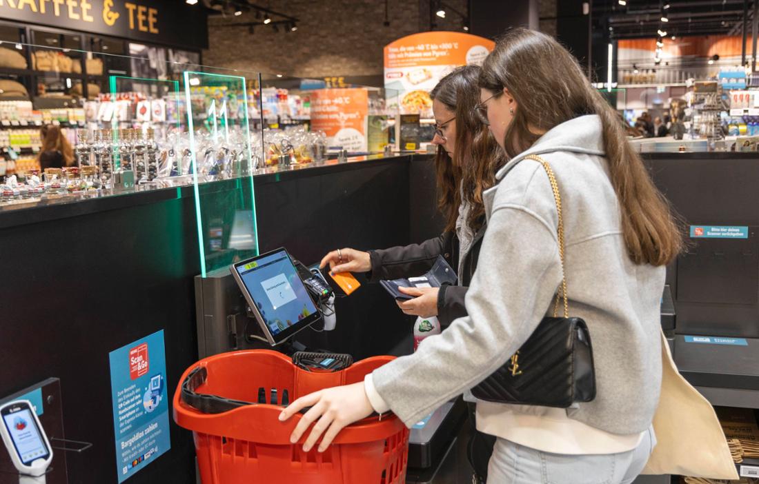 Frauen an einer SB-Kasse im Supermarkt.