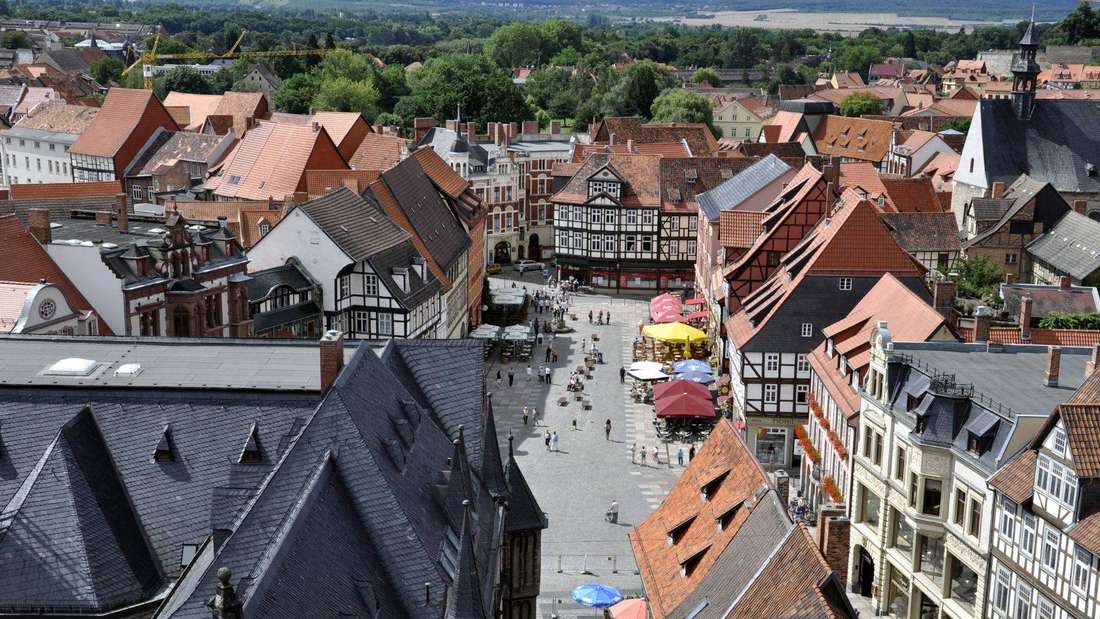 Mehrere Fachwerkhäuser stehen aneinandergereiht nebeneinander. In der Mitte ist ein größerer Platz. Links im Bild scheint eine Kirche zu stehen.