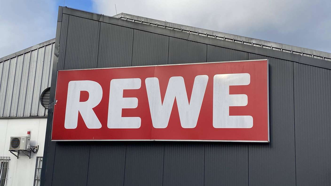 Rewe-Logo an einer Hauswand.