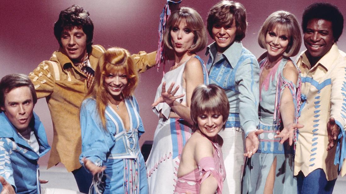 Die Kessler-Zwillinge inmitten anderer Stars der 70er-Jahre bei einer Fernsehproduktion. Alice und Ellen traten in zahlreichen TV-Shows auf und waren auch in mehreren Kinofilmen zu sehen.