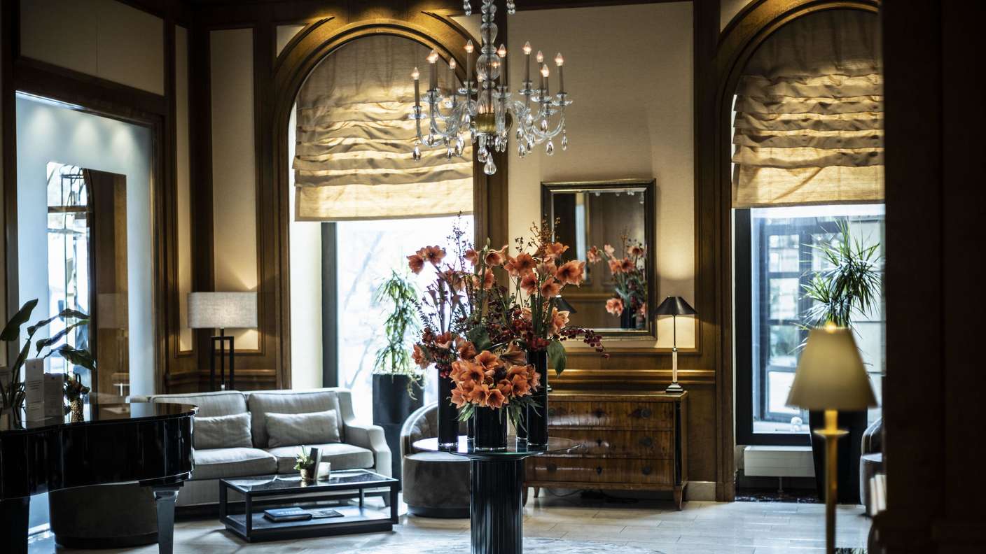 Hotel Nassauer Hof, Wiesbaden, im Bild: Innenansicht, hier Eingangsbereich Hotel Nassauer Hof. Auf einem Tisch steht Blumenschmuck. Am Rand ein Piano. Jeden Tag erklingt in der Lobby Piano-Musik.