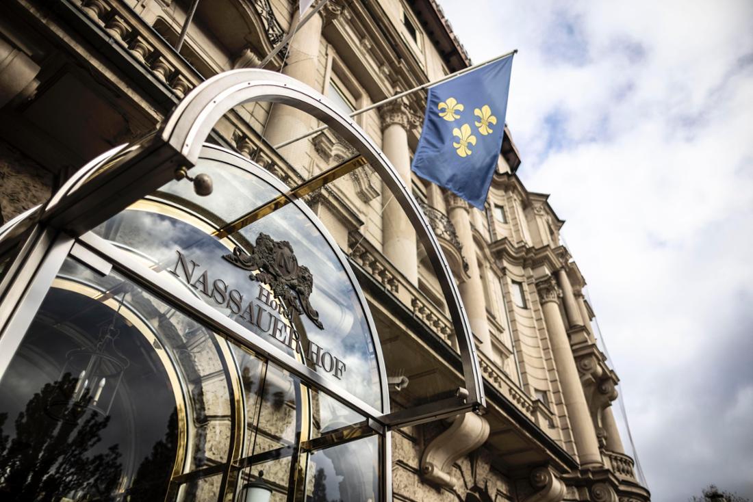 Außenansicht Hotel Nassauer Hof in Wiesbaden, Detail Vordach über dem Eingang mit Schriftzug Nassauer Hof, Wiesbaden-Fahne an der Fassade