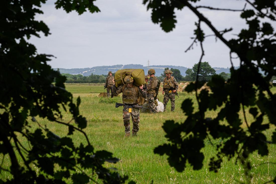 Soldiers of the 3rd Marine Infantry Parachute Regiment assemble in a field with their parachute equipment after a paradrop jump from a French military Airbus A400M aircraft as they take part in the military exercise 'Cathare 25', involving over 800 active and reserve military personnel, near Pamiers, southwestern France on June 26, 2025. (Photo by Lionel BONAVENTURE / AFP)