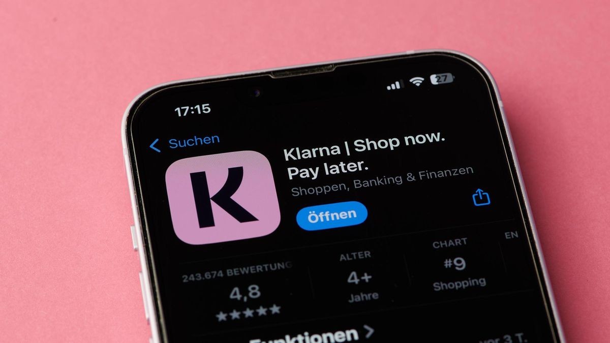 Klarna passt seine Festgeld- und Tagesgeldzinsen an. Das Klarna-App-Symbol auf einem Smartphone-Bildschirm in Deutschland auf einem rosa Hintergrund (Collage).