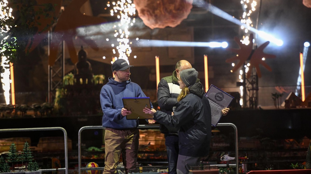 Der Moment der Wahrheit: Laura Kuchenbecker (r.) übergibt Oliver Schaffer (l.) die Rekordurkunde für das größte Urlaubs-Diorama aus Playmobil.