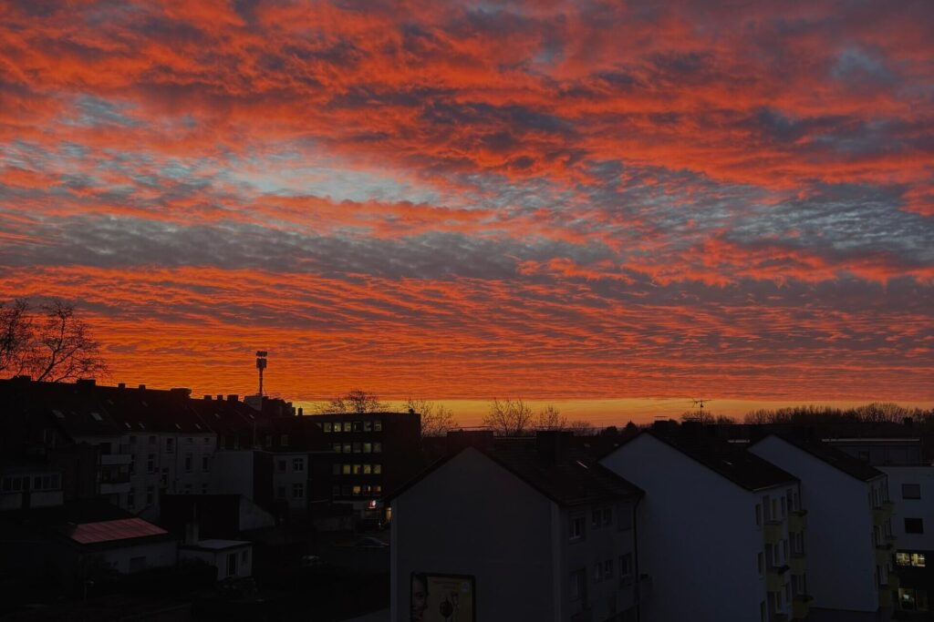 Fotos von Leserinnen und Lesern, die den bunten Sonnenaufgang über Dortmund zeigen.
