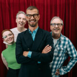 Karoline Herfurth; Olli Schulz; Joko Winterscheidt und Olli Dittrich stehen vor einem roten Vorhand und schauen lächeln in die Kamera.