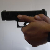 Ein Mensch hält eine Pistole im Anschlag