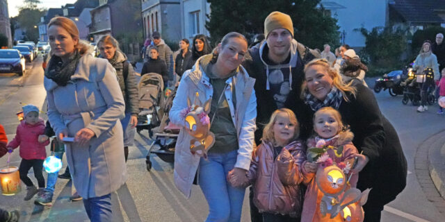 Familien mit Kindern, die Laternen tragen, auf der Schloßstraße in Bodelschwingh.