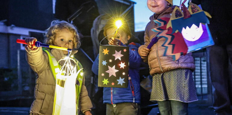 Drei Kinder zeigen ihre Laternen beim Umzug zu St. Martin 2025 in Dortmund-Wickede.
