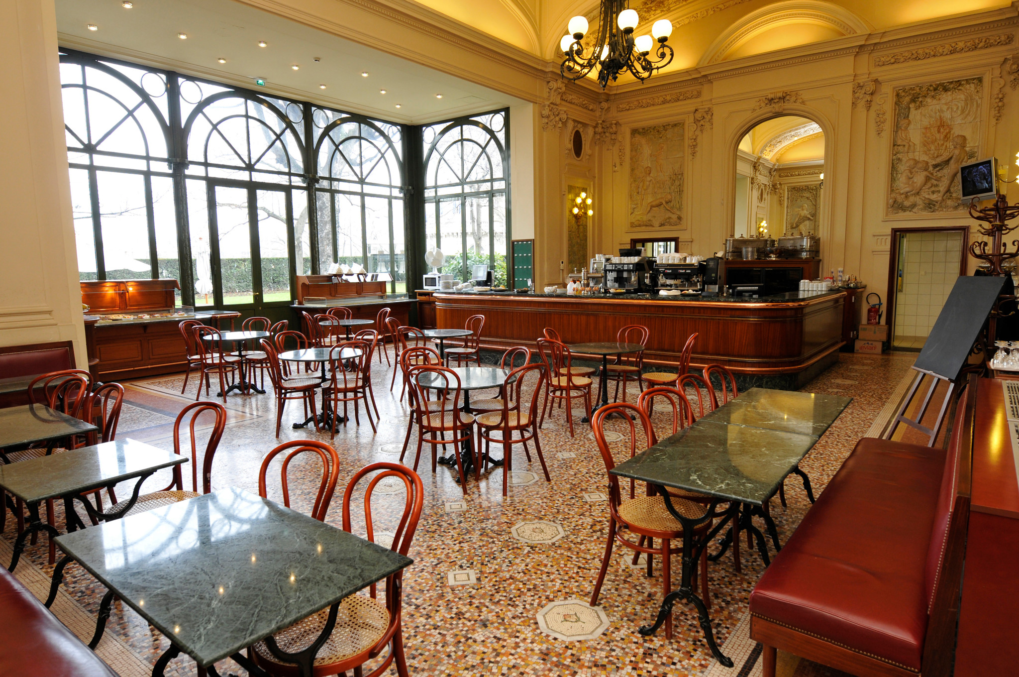 Innenansicht der Buvette der Parlamentarier von 2009 mit leeren Holzstühlen, Marmortischen und grossen Fenstern im Hintergrund.