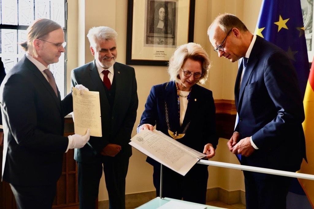 Leopoldina-Präsidentin Bettina Rockenbach überreicht Friedrich Merz eine Kopie des handschriftlichen Lebenslaufs von Albert Einstein, der nach seinem Nobelpreis Mitglied der Akademie wurde.