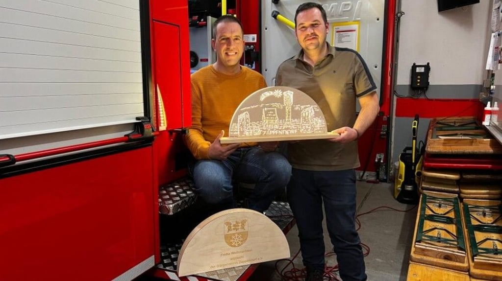 Maik Rose (l.) und Alexander Rühl halten stolz die kleine Version des Zappendorfer Schwibbogens in den Händen.