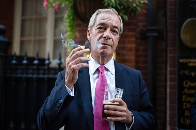 Nigel Farage raucht 2024 demonstrativ eine Zigarette vor einem Pub in London um ein Zeichen zu setzen gegen die damaligen Pläne der Labour-Regierung, das Rauchen an öffentlichen Orten weiter einzuschränken.