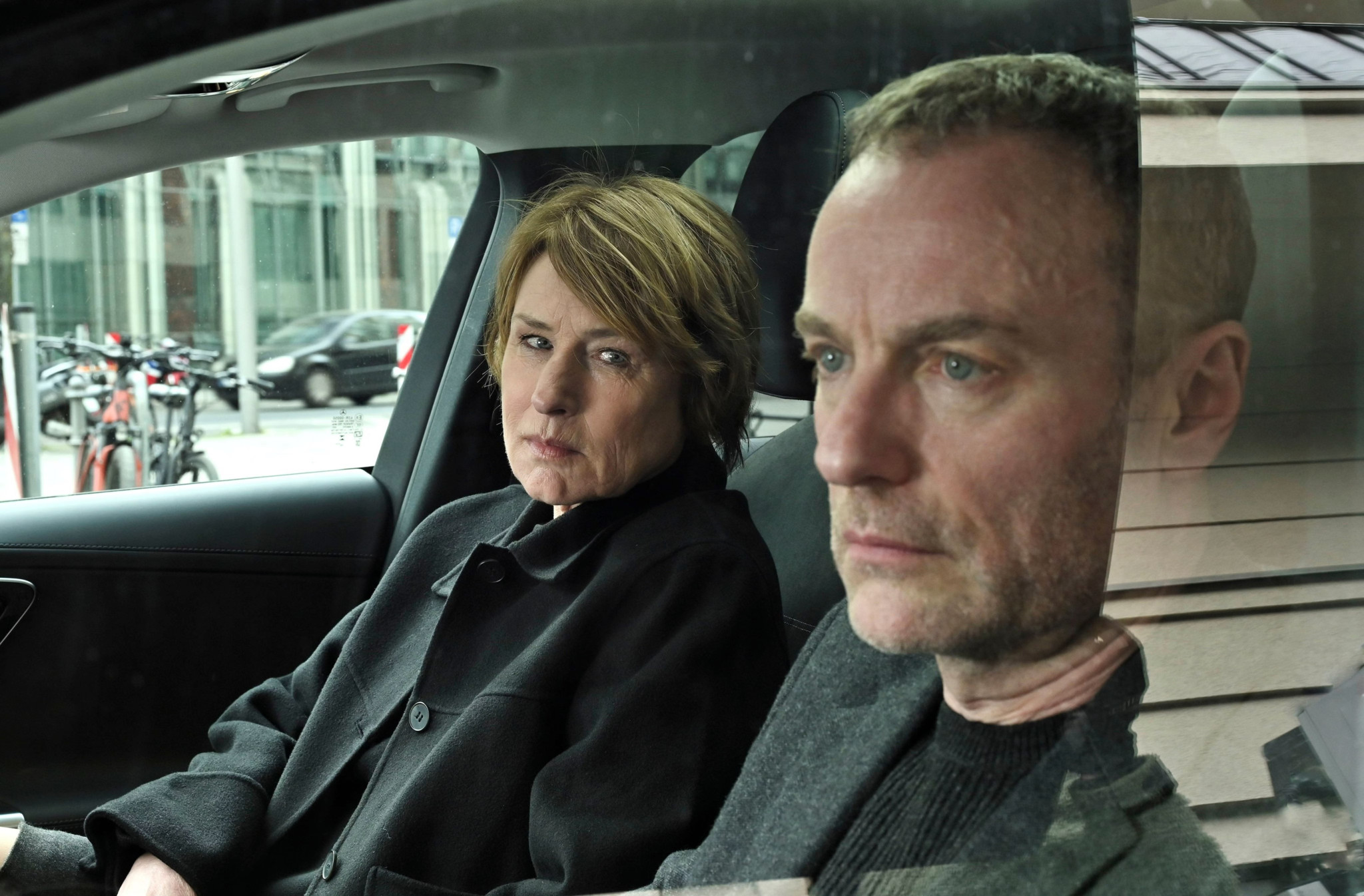Susanne Bonard (Corinna Harfouch) und Robert Karow (Mark Waschke) sitzen in einem Auto und schauen ernst aus dem Fenster.