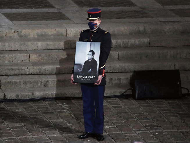 «Nur die Spitze des Eisbergs»: Bei einer Trauerfeier an der Sorbonne präsentiert ein Gardist ein Porträt des ermordeten Lehrers Samuel Paty.