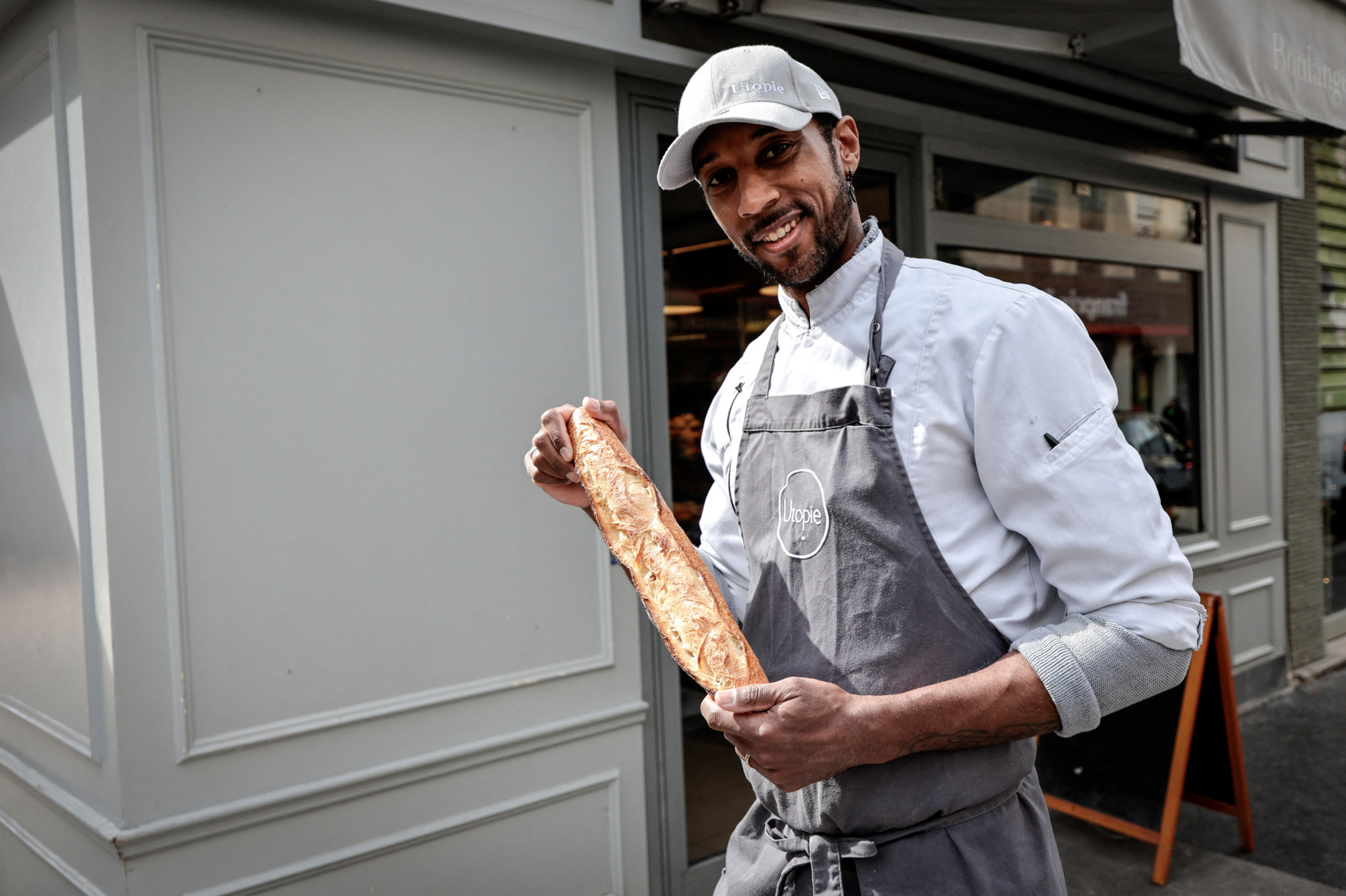 Bäcker Xavier Netry vor seiner Bäckerei ’Utopie’ in Paris mit seiner preisgekrönten Baguette, ausgezeichnet als beste Baguette 2024. Bäcker Xavier Netry vor seiner Bäckerei ’Utopie’ in Paris mit seiner preisgekrönten Baguette, ausgezeichnet als beste Baguette 2024.