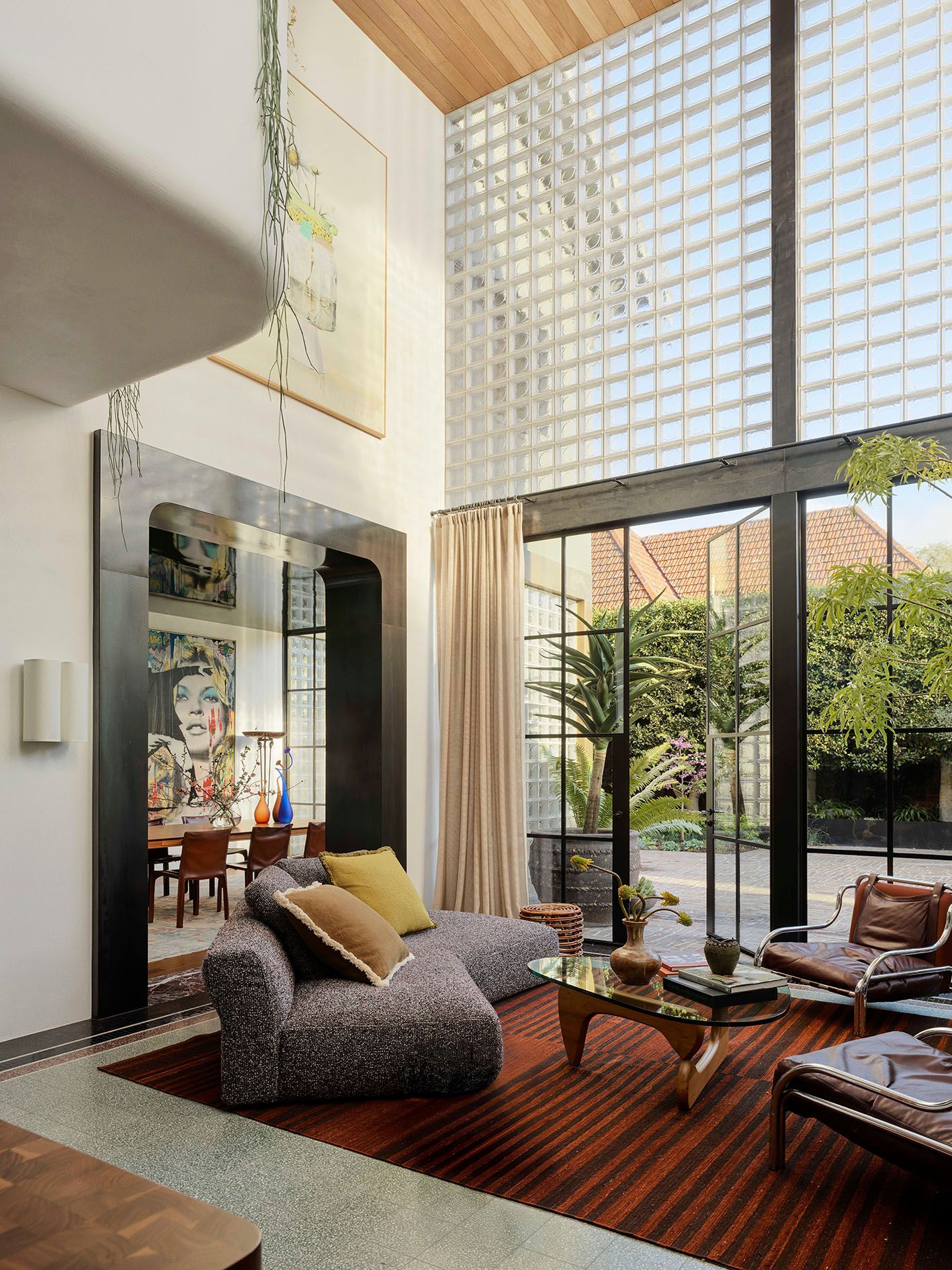 Wohnzimmer mit doppelter Raumhöhe Terrassentüren Wandflächen aus Glasbausteinen