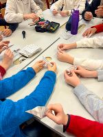 Schülerinnen und Schüler basteln gemeinsam Weihnachtsschmuck.