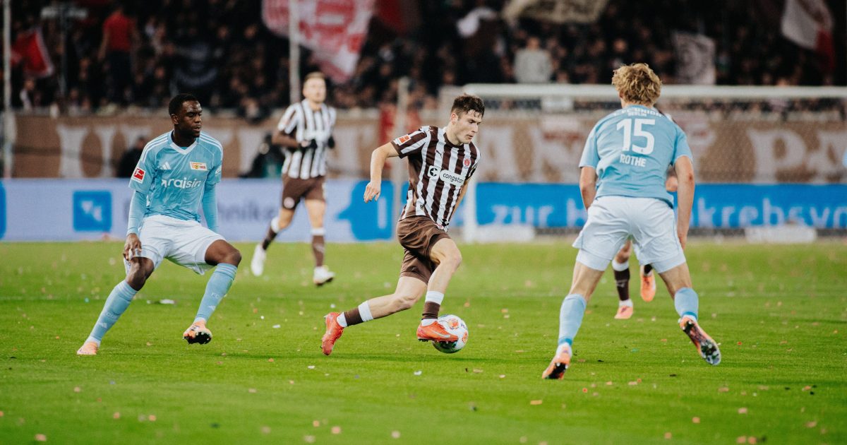Arkadiusz Pyrka mit Ball am Fuß, links und rechts von ihm sind Spieler von Union Berlin zu sehen.
