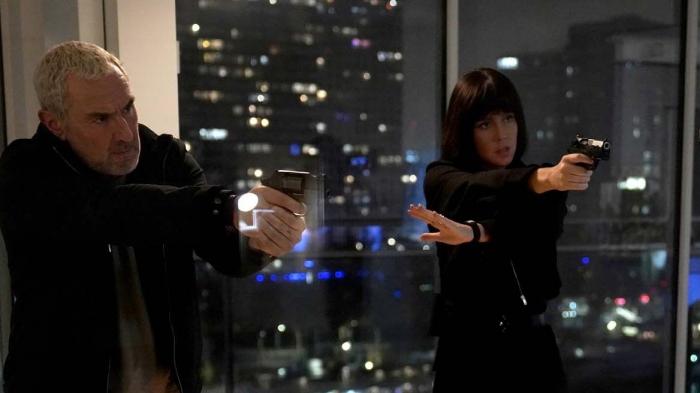 Filmbild: Drei Personen, darunter die beiden helden des Films, stehen sich mit gezückten Pistolen gegenüber