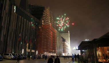 Silvester-Feuerwerk, davor ein Platz mit Menschen.