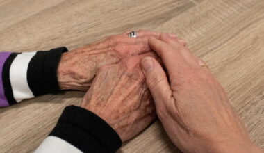 Bildbeschreibung: Jemand der von einer älteren Frau die Hand hält.