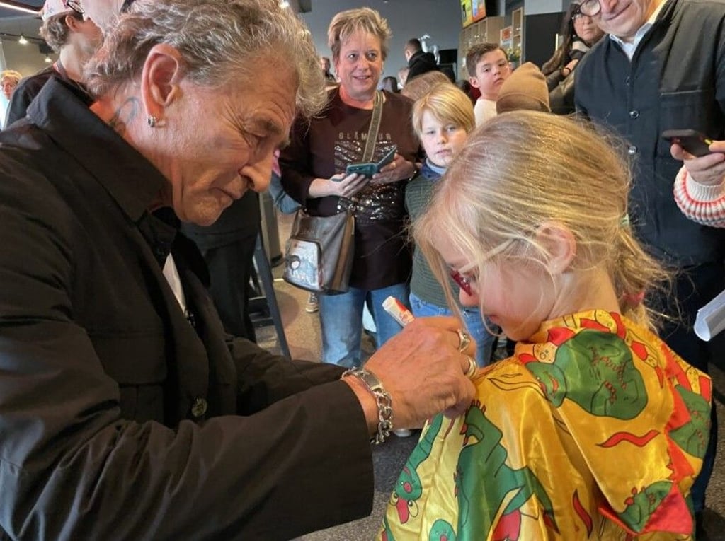 Promi-Alarm im Steintor: Rockstar Peter Maffay signiert für die sechsjährige Nele einen Umhang mit „Tabaluga“-Drachenmuster. Der Sänger stellte zur Premiere des Musicals „Anouk“ auch seine Peter-Maffay-Stiftung zugunsten benachteiligter Kinder vor.