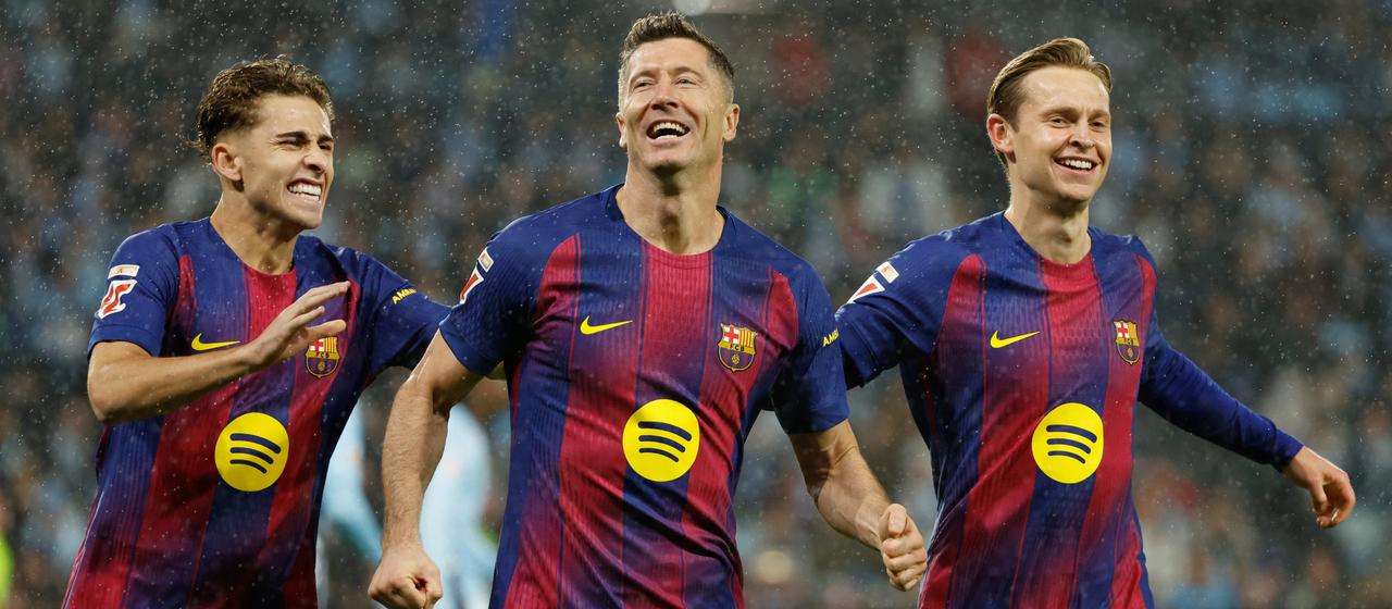 Barcelonas Robert Lewandowski (m.) feiert seinen Treffer zum 0:1 mit den Teamkollegen Fermin Lopez (l.) und Frenkie de Jong