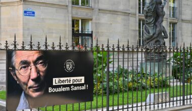 Ein Poster mit einem Porträt von Boualem Sansal und den Worten "Liberté pour Boualem Sansal!" hängt an einem Zaun im 5. Arrondissement in Paris.