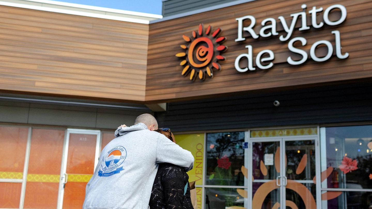 Zwei Eltern umarmen sich vor der Kita in Chicago, in der Agenten der US-Einwanderungsbehörde ICE eine Erzieherin festnahmen