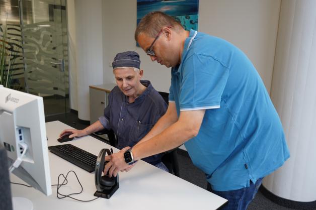 Auch am Arbeitsplatz ist Dennis Brieske stets zur Stelle. Hier unterstützt er seine Kollegin Claudia Kupzig beim Einrichten des technischen Zubehörs.