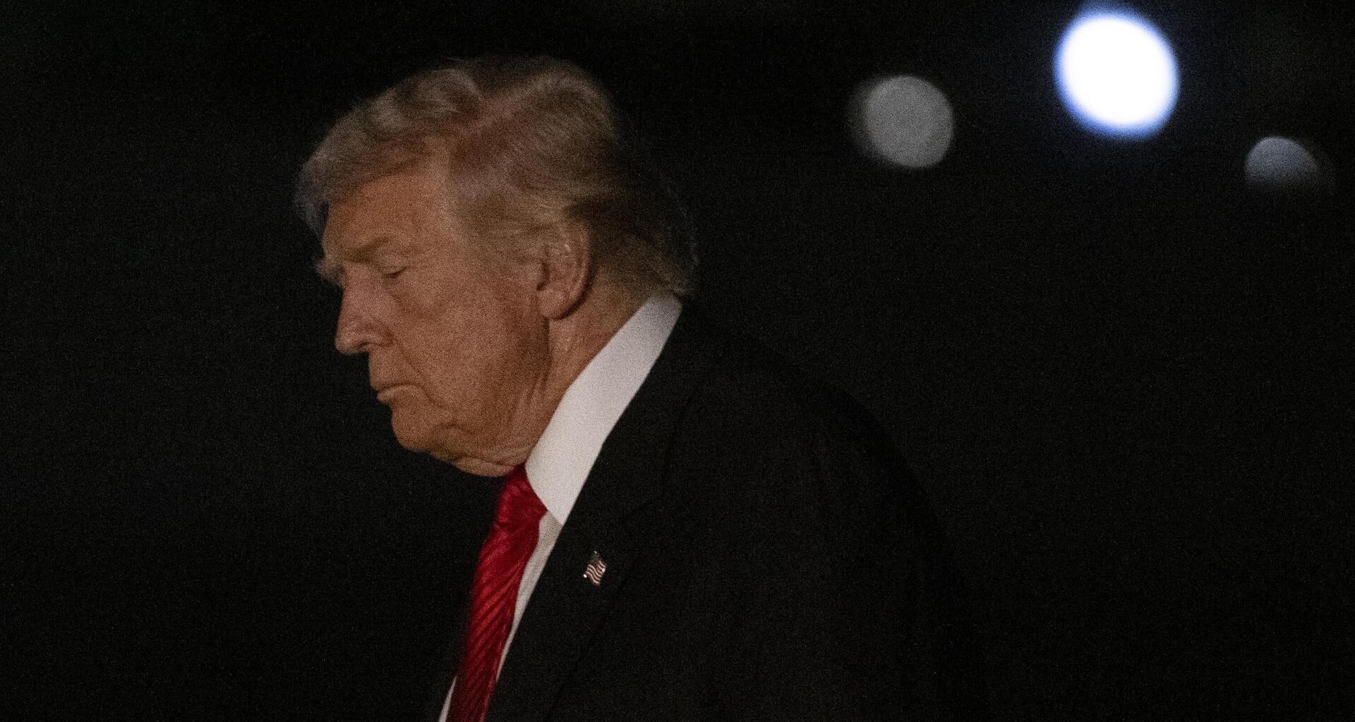 US-Präsident Trump im Anzug mit roter Krawatte in der Dunkelheit