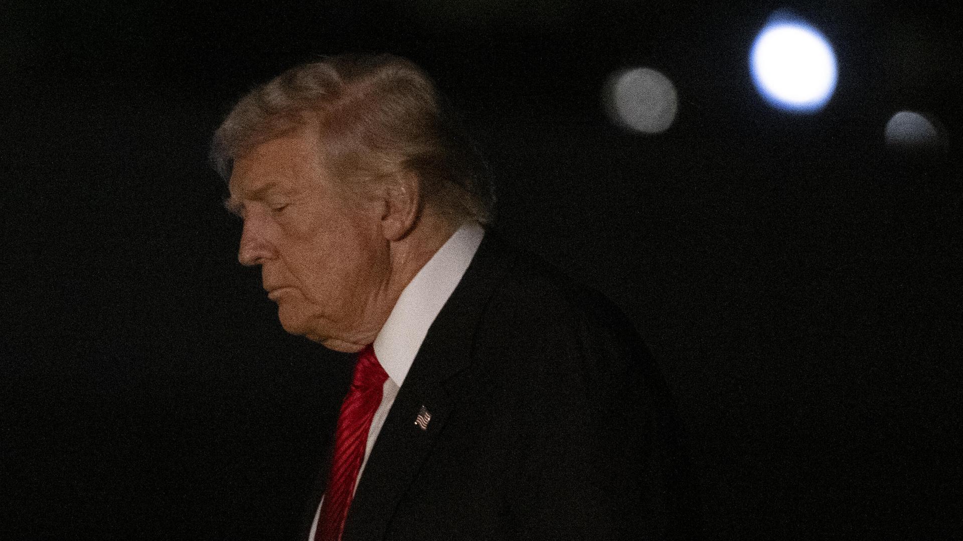 Ein Mann im Anzug mit roter Krawatte in der Dunkelheit Ein Mann im Anzug mit roter Krawatte in der Dunkelheit