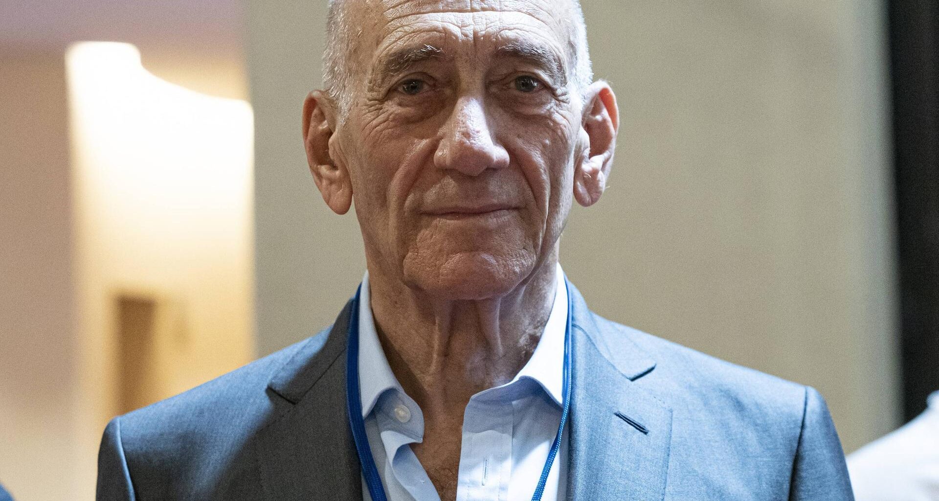 Porträt von Ehud Olmert, der einen hellen Anzug trägt und freundlich in die Kamera schaut.