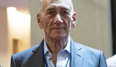 Porträt von Ehud Olmert, der einen hellen Anzug trägt und freundlich in die Kamera schaut.