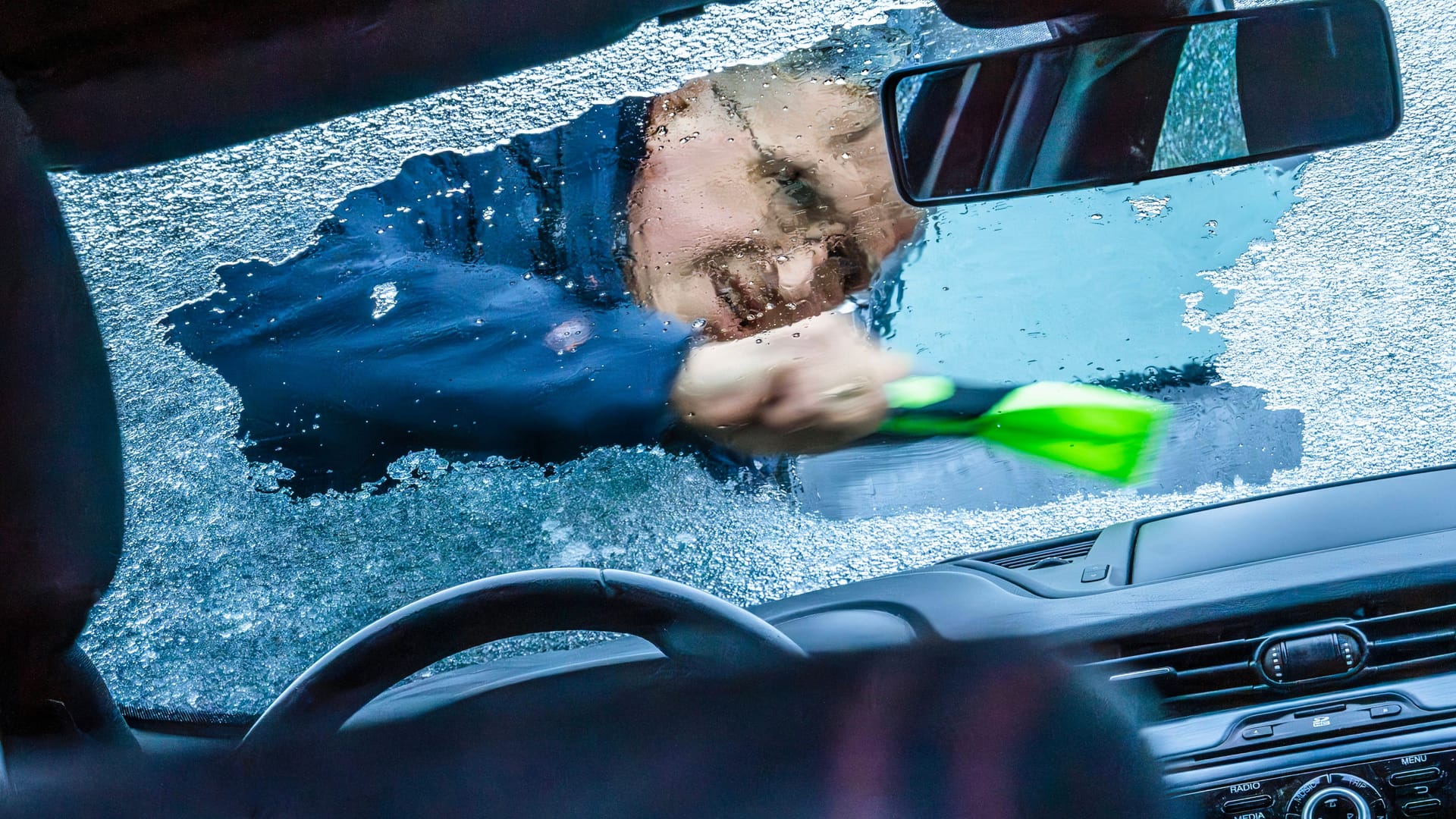 Ein Mann kämpft mit dem Frost auf seiner Autoscheibe (Symbolbild). Ein Mann kämpft mit dem Frost auf seiner Autoscheibe (Symbolbild).